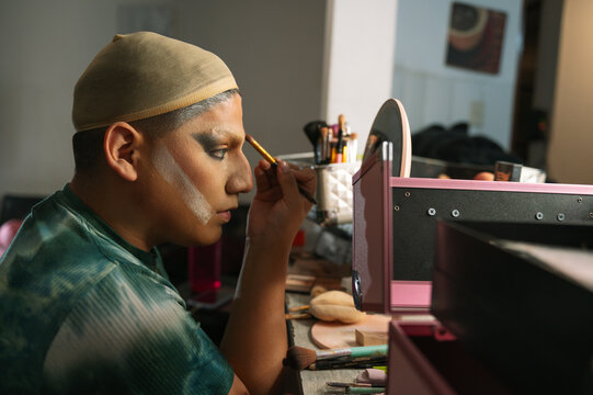 A drag queen putting on her makeup before going out to perform at a local theater in Peru.