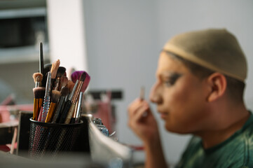 A drag queen putting on her makeup before going out to perform at a local theater in Peru.