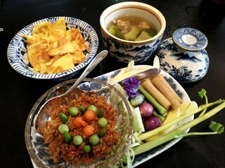 Authentic Thai home-style meal set with chili paste dip, boiled vegetables, omelette and soup in traditional ceramic ware