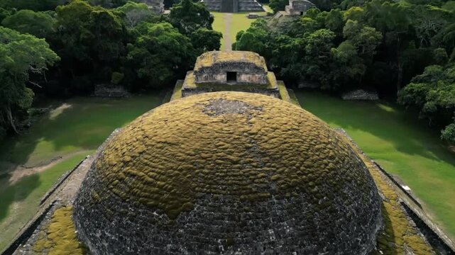 An aerial view captures the majestic mayan ruins of caracol in belize, showcasing the ancient temples and pyramids nestled within the lush green jungle