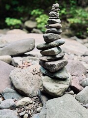 Outdoor creek feeding from the famous Kaaterskill Falls near North South Lake in Haines Falls, NY in the Catskills. Stacked grey stone rock cairn.  Tranquil wooded and water backdrop. Relax. peaceful.