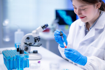 Scientist analyzing blood sample using pipette in laboratory