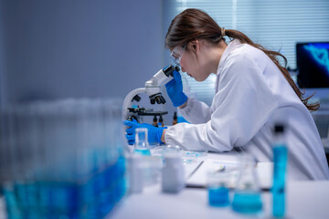 Scientist using microscope in modern laboratory researching new medicine or chemical substance