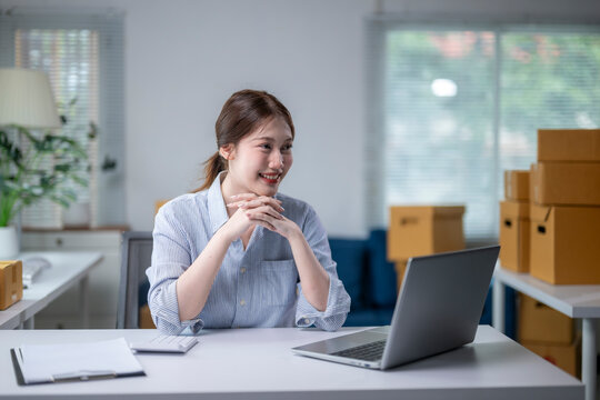 Young asian woman running e-commerce business is working in office and smiling