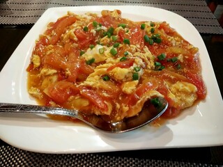 Stir-fried tomato with scrambled egg and spring onion – Asian comfort food served on white plate