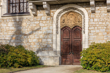 Fototapeta premium Ornate wooden door with intricate stone arch on historic building