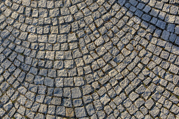 Intricate cobblestone pattern with curved design in outdoor urban setting