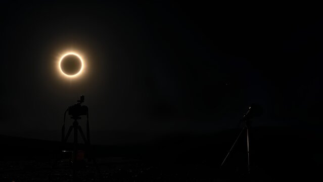 total solar eclipse, a mounted DSLR camera and telescope in the foreground