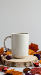Fototapeta premium Cozy autumn mug surrounded by colorful fall leaves on a wooden slice
