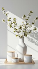 White vase with spring blossom branches and decorative jars