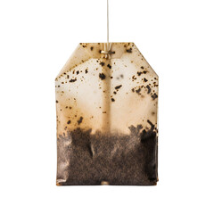 A used tea bag hangs suspended showing stains and tea residue against a transparent background