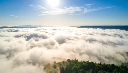 Aerial view of a mountain range emerging from a sea of clouds on a sunny day