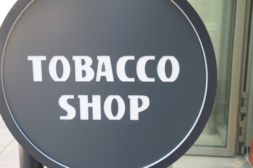 Sign indicating a tobacco shop on a busy street