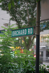 Sign indicating Orchard Road in a bustling urban setting