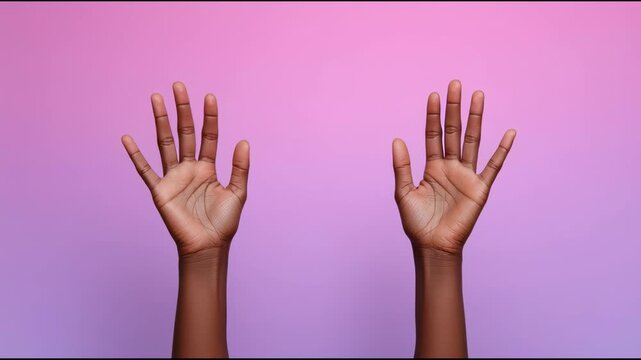 A Black person's hands held up with open palms against a pink background