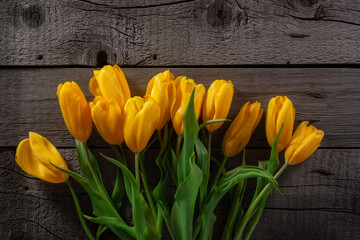 Vibrant Yellow Tulips Arranged Against Rustic Wooden Background for Spring Decor