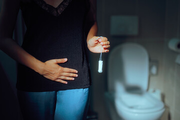 Woman Holding Tampon Complaining of Menstrual Bloating and Pain. Girl having health problems...