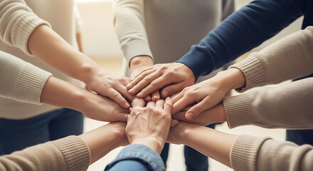 A circle of hands of different ages and ethnicities joining together in the center, symbolizing unity, support, and diversity. Soft light highlights the skin textures and different tones, creating a p