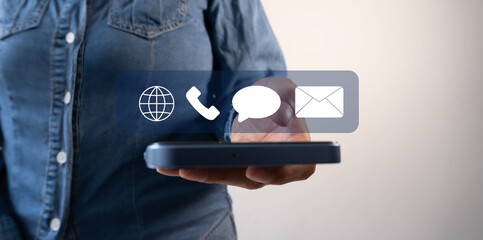 Contact forms concept. A person holding a cell phone with floating icons of a globe, a telephone, a speech bubble, and an email envelope.