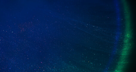 Liquid mix. Flowing ink. Defocused blue green yellow color rainbow chemical purple red sparkling...