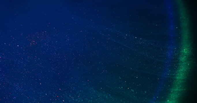 Liquid mix. Flowing ink. Defocused blue green yellow color rainbow chemical purple red sparkling water floating on abstract neon light background. - Powered by Adobe