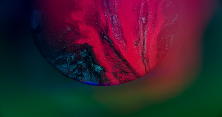 Emulsion spilling. Flowing paint. Defocused pink blue neon color glitter water floating on abstract...