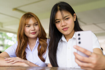 Young Thai University Students Relaxing Together at Campus Cafe Outdoors Taking Selfie Photo