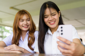 Young Thai University Students Relaxing Together at Campus Cafe Outdoors Taking Selfie Photo
