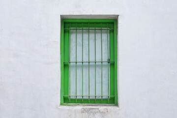Dark Green Window with Iron Bars on Textured White Wall, Classic Minimalist Architecture