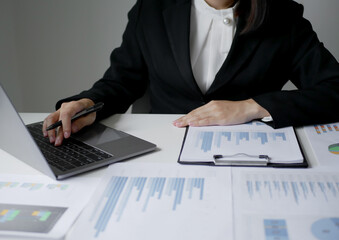 Determined and detail-oriented businesswoman studies financial charts to plan strategies and make confident decisions to achieve success in the fast-changing business world