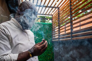 African american mature man smoking cigar in outdoor lounge