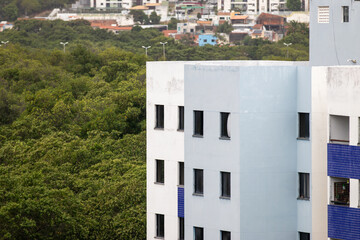 Prédio residencial ao lado de uma floresta nativa. 
