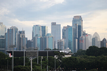 Obraz premium A high resolution image of modern skyscrapers and office towers in Jakarta central business district, Indonesia. The photo showcases glass covered buildings under a dramatic cloudy sky, representing t