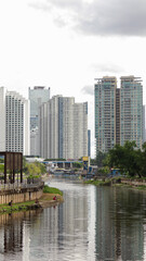 view of a public park with a lake in Jakarta in the morning with a background of modern buildings on the lake side