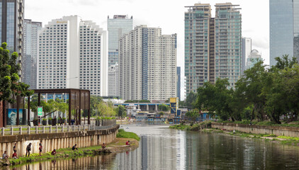 Obraz premium view of a public park with a lake in Jakarta in the morning with a background of modern buildings on the lake side