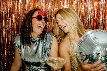 Two women laughing and having fun at a festive party