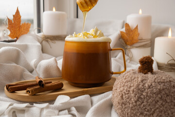 Autumn hygge Orange Cup of warm coffee autumn leaves on table against raindrops are running down the glass in window. Cozy fall still life footage burning candles. Thanksgiving and Halloween holiday