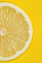 Close-Up of a Fresh Lemon Slice with Juicy Interior Against a Yellow Background