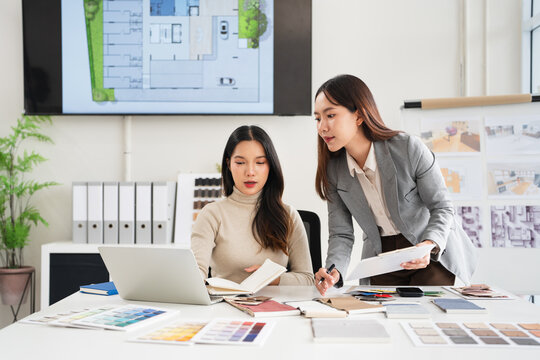  interior designer working on new house design project in office. choosing finishing flooring and furniture materials and colors from samples.