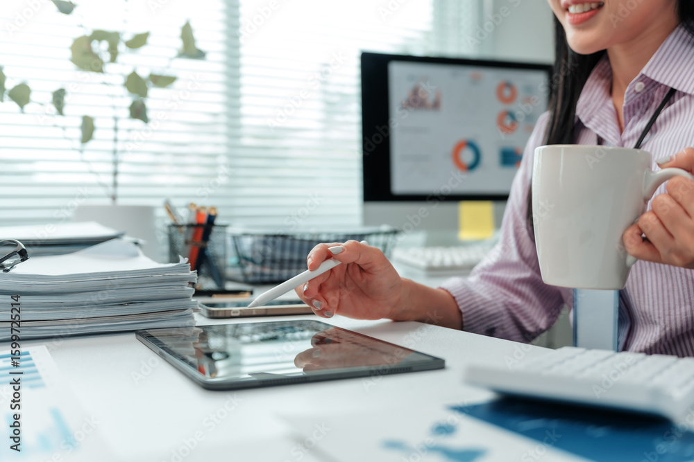 Poster businesswoman using digital pen while working with tablet and drinking coffee, with computer showing