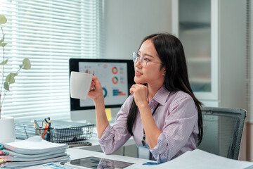 Young office worker sipping coffee while contemplating innovative business ideas, focused on a...
