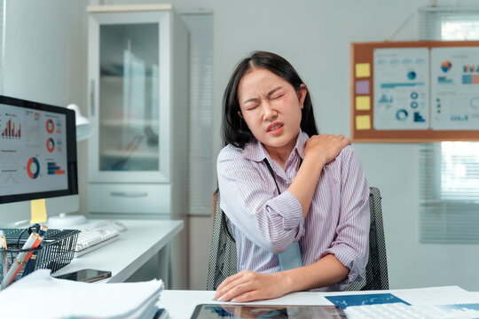 Young office worker feeling tired, exhausted, and suffering from shoulder and neck pain after long hours working with a computer in office, health care concept - Powered by Adobe