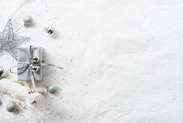 Set of silver Christmas decorations on paper texture background, silver decorative present, silver...