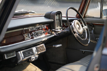 Vintage Classic car steering wheel, with chrome and leather textures in sharp detail, showcases the...