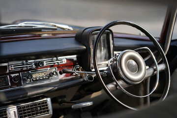 Vintage Classic car steering wheel, with chrome and leather textures in sharp detail, showcases the...
