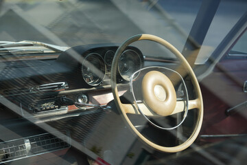 Vintage Classic car steering wheel, with chrome and leather textures in sharp detail, showcases the...