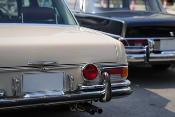 A chrome keyhole above the license plate and a polished rear trunk lock system on a vintage car...