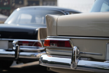 The tail lights, turn signals, and chrome accents on the rear of classic cars exude vintage charm...