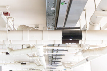 Structure plastic pipes under building or apartment with aluminum cable tray. Plumbing rough-in or electrical conduit in commercial building with pvc pipe in construction site of apartment.