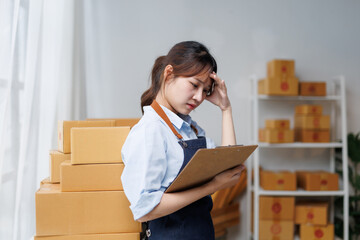 Young entrepreneur woman holding clipboard and touching her head, having a headache and feeling...